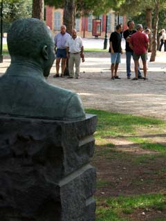 Bronze bust of jazz musician Louis Armstrong appears to be watching a group of Frenchman playing Petank infront of the Matisse museum and immediately adjacent to the gallo-roman ruins.