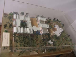 A scale model is under plexiglass.  The buildings are surrounded by trees and separated by courtyards.