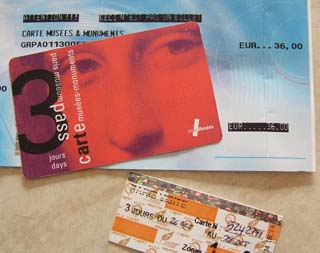 A red card with the image of the Mona Lisa looking back is on top of a blue receipt for 36 euros.  Below is a small multicolored strip of paper that is for a three day pass through the Paris Metro.
