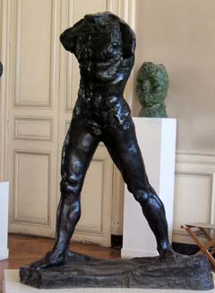 A muscular masculine figure without arms or head is realistically depicted in bronze.