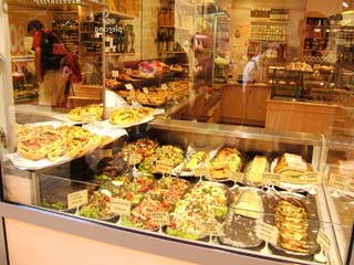 An array of expensive prepared foods in the window of a shop in Cannes.  Typical prices are 45 euros per kilo for a seafood salad.