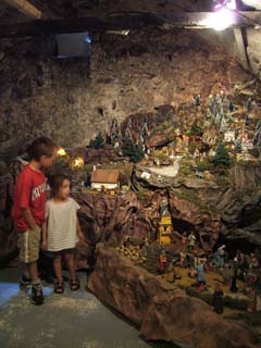 My children looking at a room-sized creche with all sorts of medieval activity depicted.