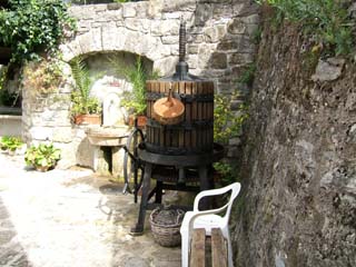 A small terrace in a quaint medieval French town is decorated with an old winepress and cheap plastic chair.  To me this is the ultimate demonstration of the travelers paradox.  Perhaps we should learn to like that plastic chair.