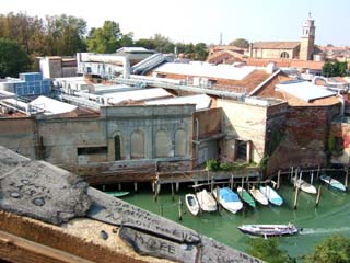 view of one of the venice canals and jumbleof buildings beyond.  The edge of the hatch shows graffitti.