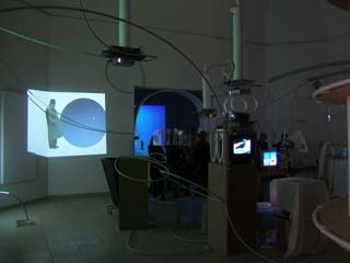 A room ful of gadgets, wires, tubing, video screens, and enegmatic projections.