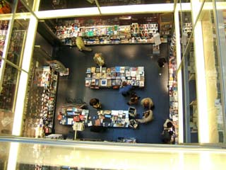 View from three floors above the floor of a bookstore.  Picture is framed by the sides of a vertical atrium.