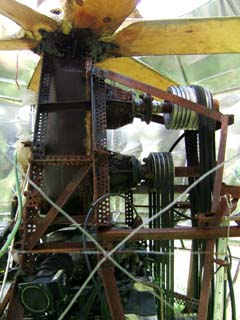 Six bladed wooden propellor connected to a haphazardly constructed collection of machinery shows signs that it was actually operated.