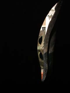 View from inside the large bronze head above.  Looking through the hole for the eyes is a view of another collosal head on the other side of the piazza.