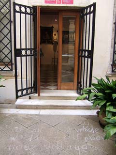 an open door with a message written on the stone walk.  The message is mostly worn away but reads "Don't cry for the whole world--tell about your own village."