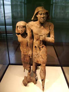 the faces of this man and woman are in perfect condition but the base and legs have nearly rotted off.  The stance is the stiff formality of Egyptian art but the expressions are less serious.  Their position seems what one would excpect of two members of an adoring crowd.