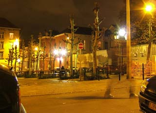 A shodowy image of a man walking is barely visible amidst a lighted street on Holloween night.