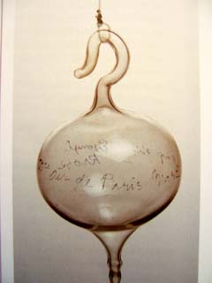 A small, hand blown glass bubble has handwriting "Air de Paris".