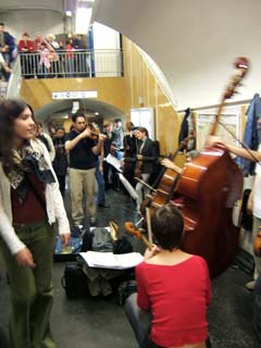 Several musicians playing classical woodwind instruments in a Metro station.