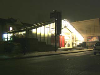 A mostly glass building glows in the dark.